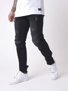 Jeans slim efecto desteñido y desgastado con agujeros negros